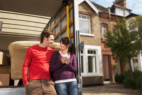 Professional movers handling office furniture and equipment during a Barbican relocation